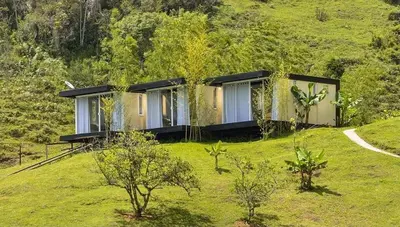 a house sitting on top of a grassy hill at Pietrasanta hotel campestre frente a la represa del Peñol y Guatape in Guatapé