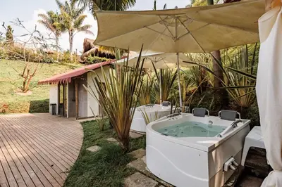a bath tub sitting under an umbrella in a yard at Pietrasanta hotel campestre frente a la represa del Peñol y Guatape in Guatapé