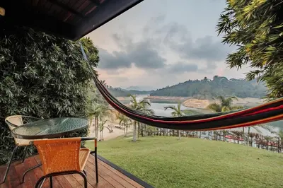 a hammock on a deck with a view of a river at Pietrasanta hotel campestre frente a la represa del Peñol y Guatape in Guatapé