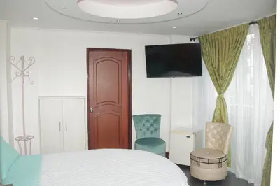 a bedroom with a bed and a flat screen tv at Hotel Dubai in Manizales