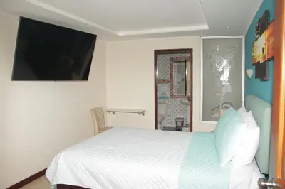 a bedroom with a bed and a flat screen tv at Hotel Dubai in Manizales