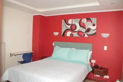a red bedroom with a bed and a red wall at Hotel Dubai in Manizales