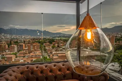 a glass vase sitting on a couch in front of a window at Cavalta by Bernalo Hotels in Medellín