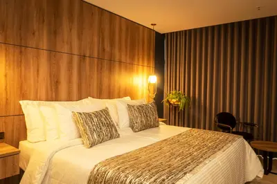 a bedroom with a large bed with a wooden wall at Cavalta by Bernalo Hotels in Medellín