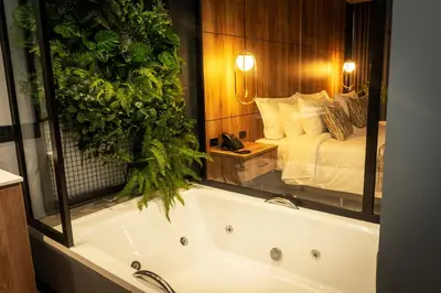 a bath tub in a bedroom with a bed at Cavalta by Bernalo Hotels in Medellín