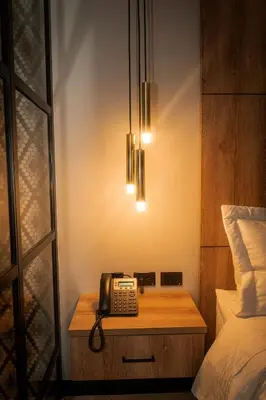 a bedroom with a bed and a phone on a table at Cavalta by Bernalo Hotels in Medellín