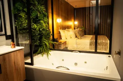 a bath tub in a room with a bed at Cavalta by Bernalo Hotels in Medellín