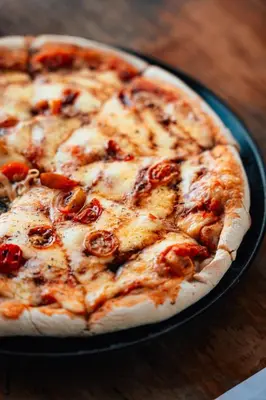 a pizza sitting on top of a pan on a table at The Boato Hotel in Guatapé