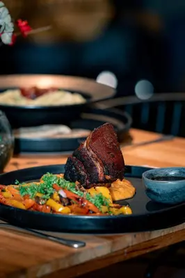a plate of food with meat and vegetables on a table at The Boato Hotel in Guatapé