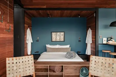 a bed in a room with a blue wall at The Boato Hotel in Guatapé
