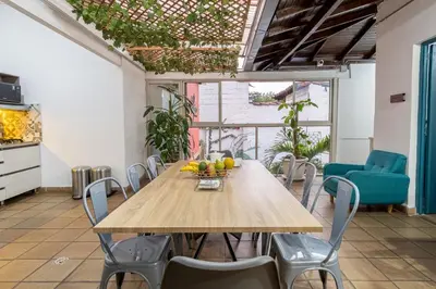 a dining room with a wooden table and chairs at Botánica Casa Hotel in Medellín