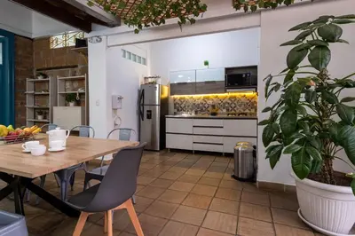 a large kitchen with a wooden table and chairs at Botánica Casa Hotel in Medellín