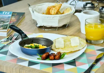 a table topped with a plate of food with eggs and cheese at Botánica Casa Hotel in Medellín