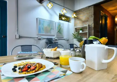 a table with a plate of breakfast food on it at Botánica Casa Hotel in Medellín
