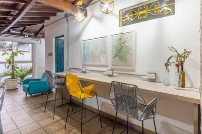 a bar with chairs and a counter in a room at Botánica Casa Hotel in Medellín