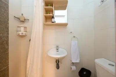 a small bathroom with a sink and a shower at Botánica Casa Hotel in Medellín