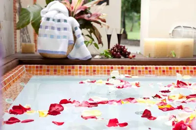 a pool filled with red and yellow flower petals at Hotel y Spa Santa Fe Colonial in Santa Fe de Antioquia