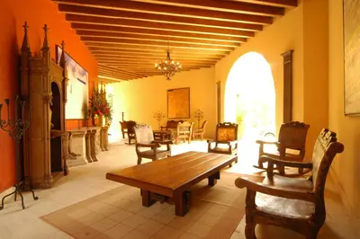a living room with a wooden table and chairs at Hotel y Spa Santa Fe Colonial in Santa Fe de Antioquia