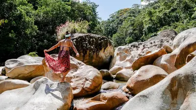 a man is riding a camel in the water on rocks at La Perla Negra - Black Pearl Eco Hostel in San Rafael