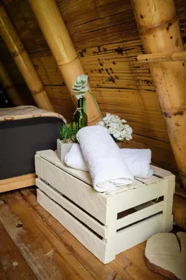 a stack of crates with towels and flowers on a bed at La Perla Negra - Black Pearl Eco Hostel in San Rafael