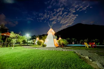 a windmill in a yard at night at Cerro Tusa Glamping in Titiribí