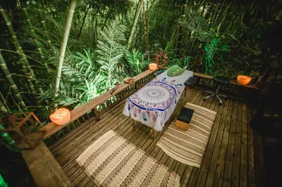 a wooden deck with a table and a laptop on it at Cerro Tusa Glamping in Titiribí