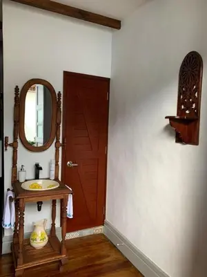 a bathroom with a sink and a mirror next to a door at La Estancia Hotel Boutique in Salamina