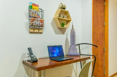 a desk with a laptop and a phone on it at Modern Apartment Ultra Fast Internet in El Poblado in Medellín