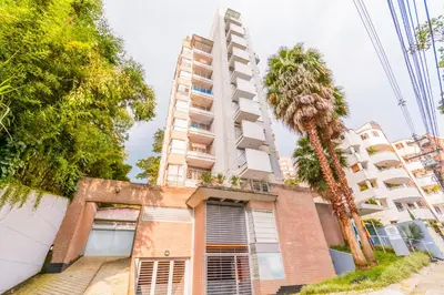 a tall building with a palm tree in front of it at Modern Apartment Ultra Fast Internet in El Poblado in Medellín