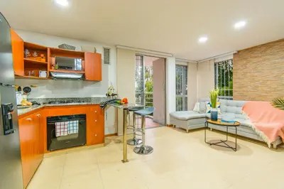 a kitchen with a counter and a living room at Modern Apartment Ultra Fast Internet in El Poblado in Medellín