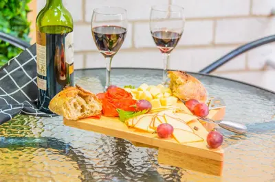a plate of food on a table with two glasses of wine at Modern Apartment Ultra Fast Internet in El Poblado in Medellín