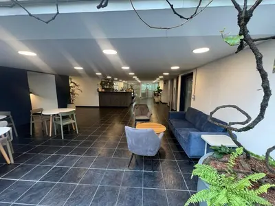 a lobby with a blue couch and chairs and tables at Modern Apartment Ultra Fast Internet in El Poblado in Medellín