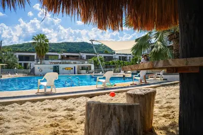 a beach with chairs and a swimming pool at Apartasol Santa Fe de Antioquia in Santa Fe de Antioquia