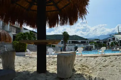 a view of a beach with chairs and a pool at Apartasol Santa Fe de Antioquia in Santa Fe de Antioquia