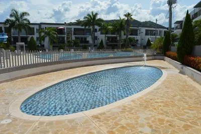 a swimming pool with a fountain in front of some buildings at Apartasol Santa Fe de Antioquia in Santa Fe de Antioquia