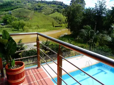 a balcony with a view of a river and mountains at HOTEL EL POTRILLO in El Peñol