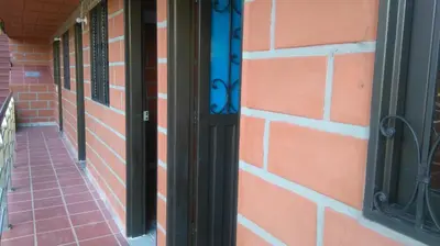 a red brick wall with a black door at HOTEL EL POTRILLO in El Peñol