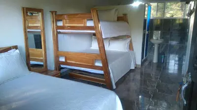 a bedroom with two bunk beds and a bathroom at HOTEL EL POTRILLO in El Peñol