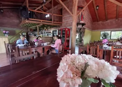 a group of people sitting at tables in a restaurant at HOTEL EL POTRILLO in El Peñol