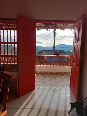 an open door to a balcony with a cat sitting on the floor at Casa Hotel Villa Marta in Jericó