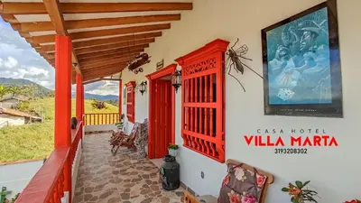 a house with red trim and a balcony at Casa Hotel Villa Marta in Jericó