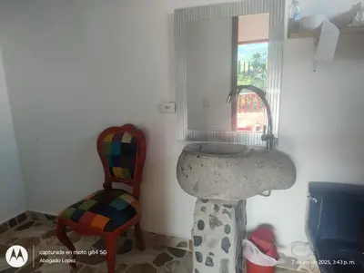 a bathroom with a sink and a chair and a mirror at Casa Hotel Villa Marta in Jericó