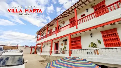 a white car parked in front of a building with an umbrella at Casa Hotel Villa Marta in Jericó