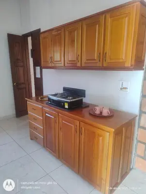 a kitchen with wooden cabinets and a microwave on a counter at Casa Hotel Villa Marta in Jericó