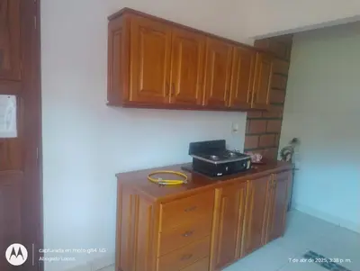 a kitchen with wooden cabinets and a microwave on a counter at Casa Hotel Villa Marta in Jericó