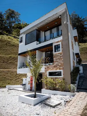 a building with a palm tree in front of it at Monte Gandolfo in Guatapé