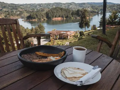 a table with a pan of food and a plate of bread at Monte Gandolfo in Guatapé