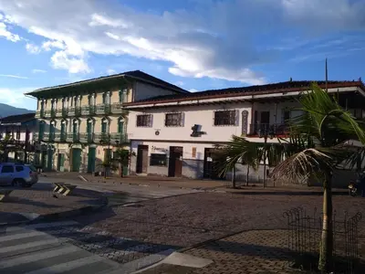 a building with a palm tree in front of a street at Hotel Tahami in Sonsón