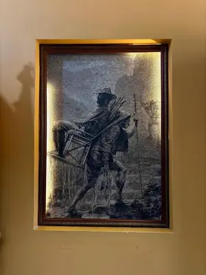 a painting of a man in a chair on a wall at Hotel Tahami in Sonsón
