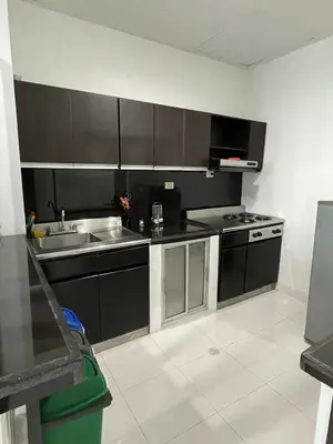 a kitchen with black cabinets and a sink at Hotel Boutique San Rafael in Mariquita